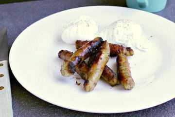 plate with low carb maple breakfast sausages and two poached eggs.