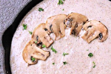 Cast iron skillet filled with keto mushroom sauce.
