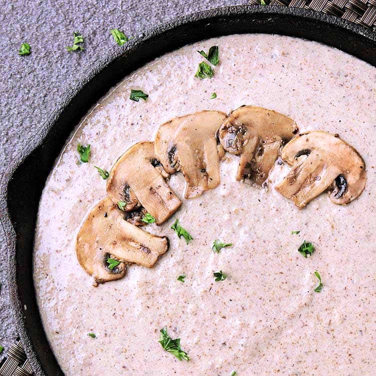 Cast iron skillet filled with keto mushroom sauce.