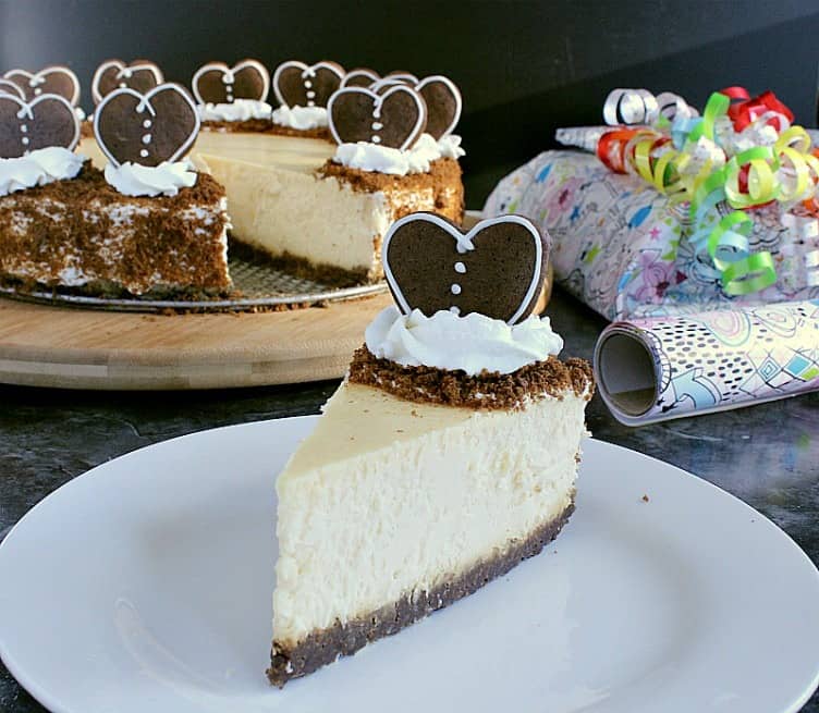 gingerbread crust cheesecake with one slice removed and decorated with hearts instead of trees.