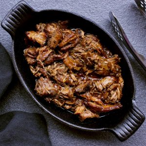cast iron dish loaded with keto pulled pork