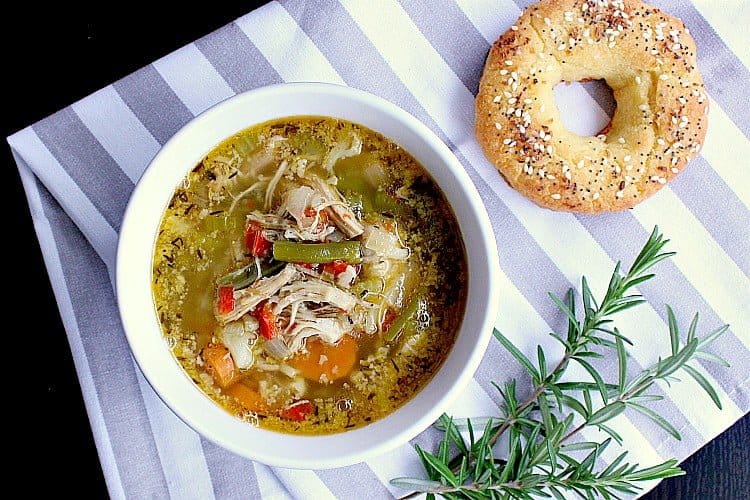 Bowl of soup next to a low carb bagel.