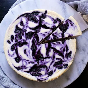 Serving Keto Blueberry Cheesecake on a marble platter.