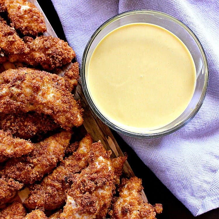 Keto Honey Mustard next to a platter of crispy chicken tenders.