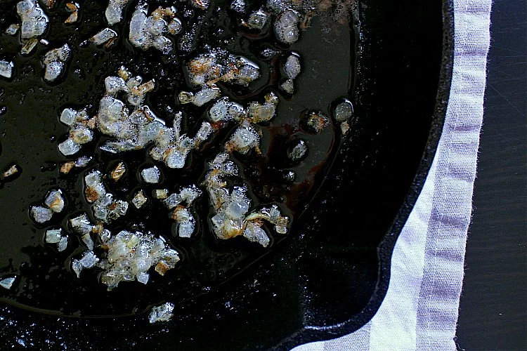 Cast iron skillet with fried minced onions.