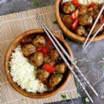 Two wooden bowls of keto sweet and sour meatballs with cauliflower rice.
