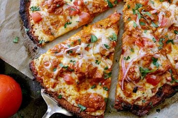 Keto Butter Chicken Pizza sliced into 8 pieces and garnished with cilantro.