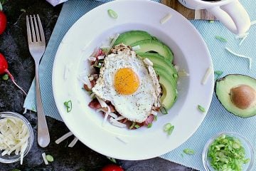 Low Carb Hash Boat. Bed of roasted radishes with bacon, grated cheese and green onion. Fried egg on top with sliced avocado beside it.