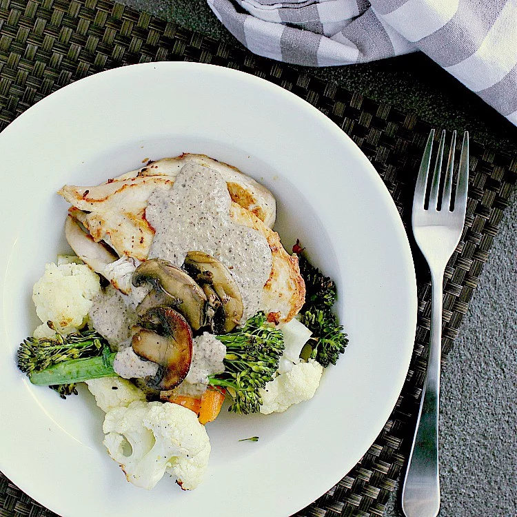 Seared chicken breast with roasted vegetables and covered in keto mushroom sauce.