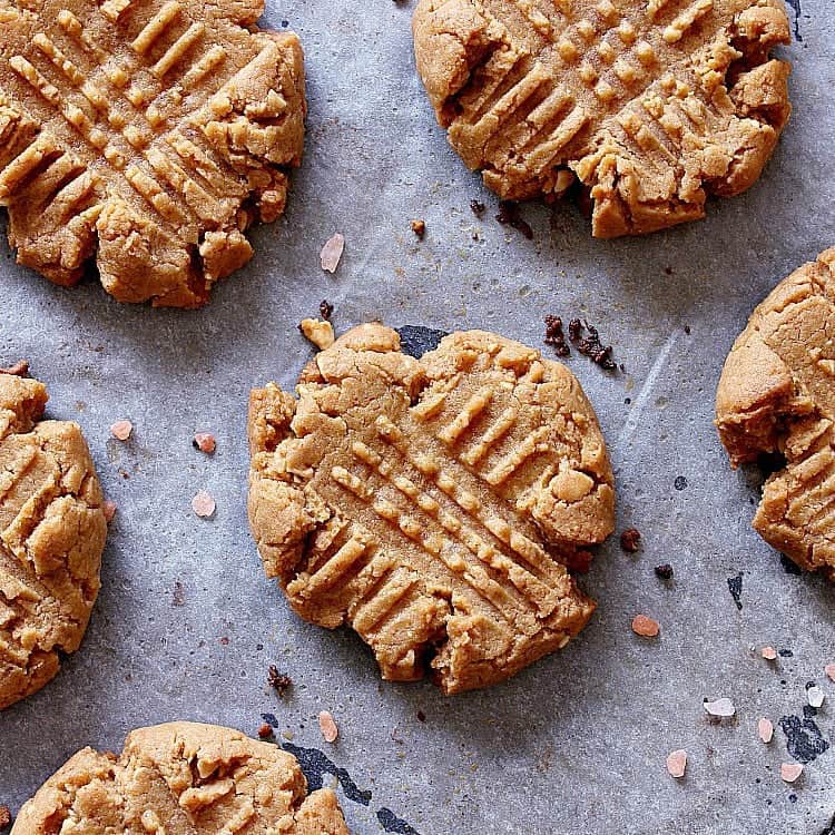 Low carb peanut butter cookies cooling on a baking sheet with parchment paper.