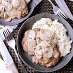 Bowl of mashed cauliflower topped with keto salisbury steak and mushroom sauce.