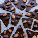 Keto Almond Bark broken into pieces, on parchment paper.