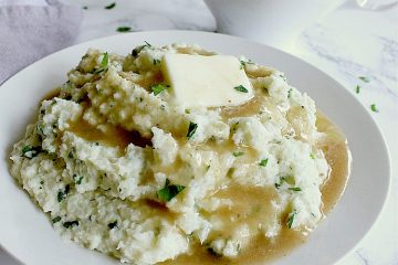Bowl of keto mashed cauliflower topped with butter and keto gravy.