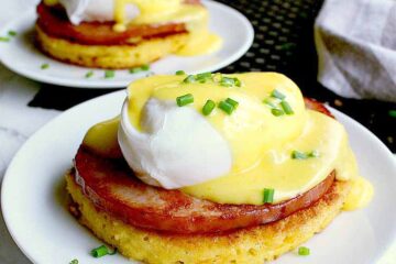 Two plates each with a keto eggs benedict and garnished with chives.