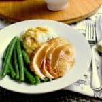 Plate with chicken, green beans and mashed cauliflower, all covered in keto gravy.