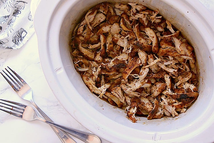 Slow cooker with shredded chicken.
