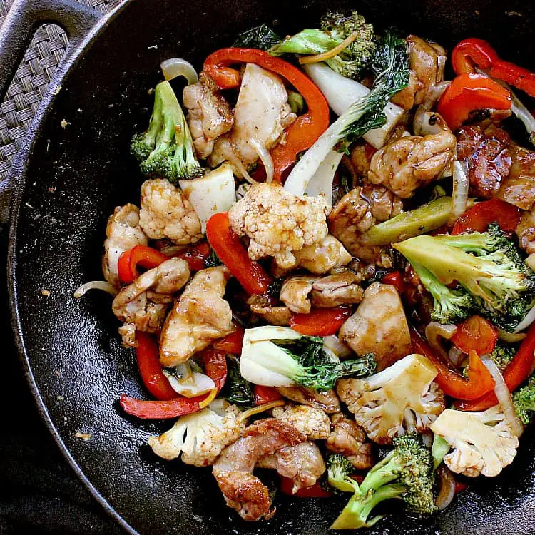 Cast iron skillet filled with Keto Chicken Stir Fry, ready to be served.
