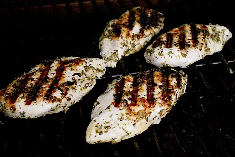 Grilled keto greek chicken breasts on the grill.