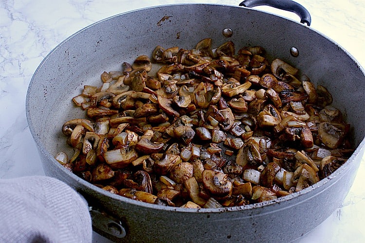 Skillet with fried onions and mushrooms.