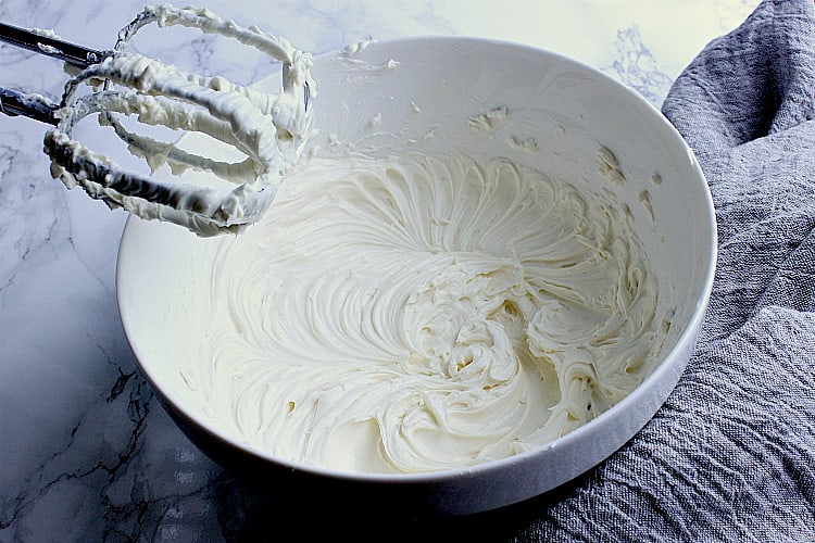 White bowl with whipped cream cheese and powdered sweetener.