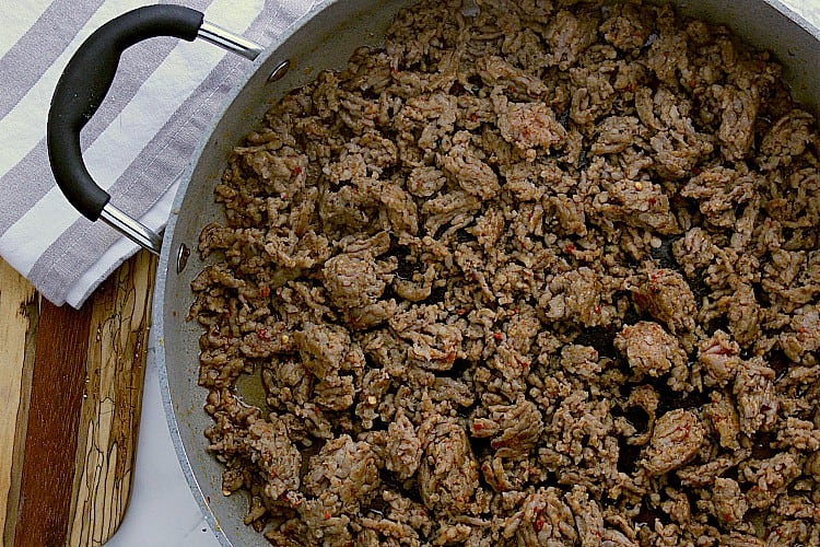 Fried sausage in a skillet.