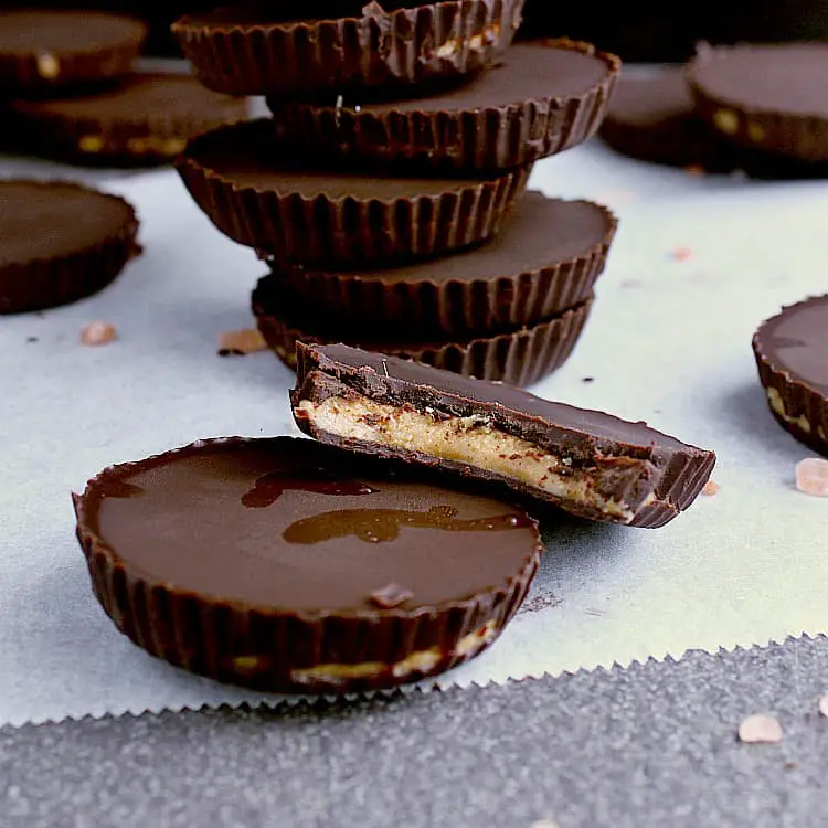 A stack of Keto Peanut Butter Cups with two in front, one has a bite removed.