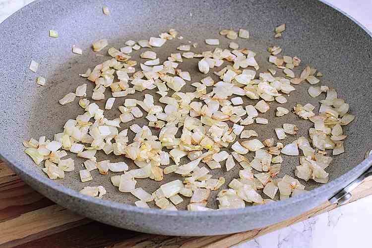 A skillet with fried onion and garlic.