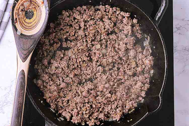 Cast iron skillet with cooked meat.