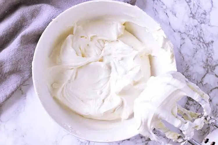 A white bowl with creamed cream cheese and sweetener.