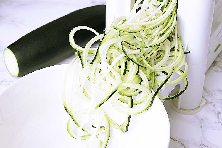 A vegetable spiralizer making zucchini noodles.